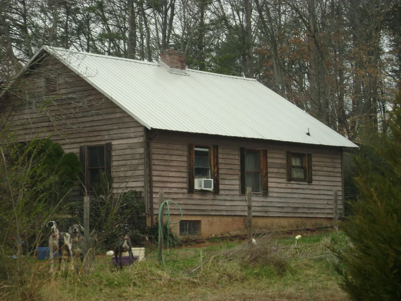 White metal roof on an old wood sided farmhouse, from a Metal Roof Installation job in War